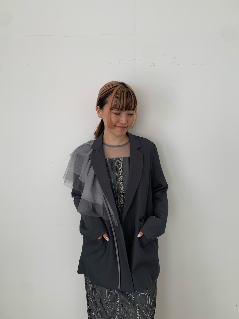 グレー系のドレス、グレー系のジャケット/アウター、ブラック系のパンプスを着用したレディースの春コーディネートの3枚目の写真