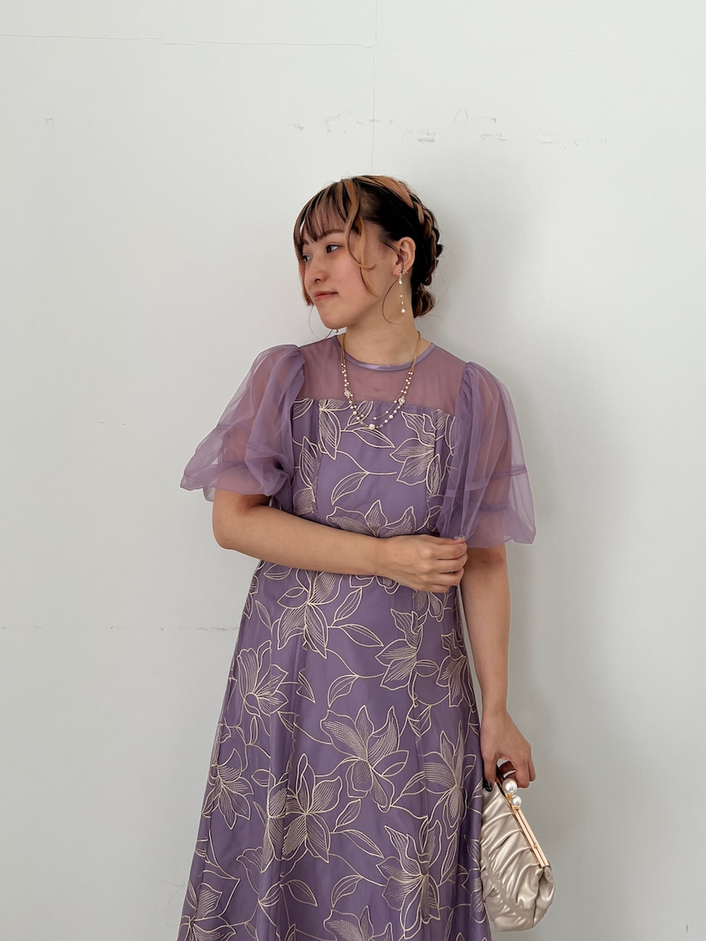 ゴールド系のバッグ、ベージュ系のシューズ、パープル系のドレスを着用したレディースの夏コーディネートの2枚目の写真