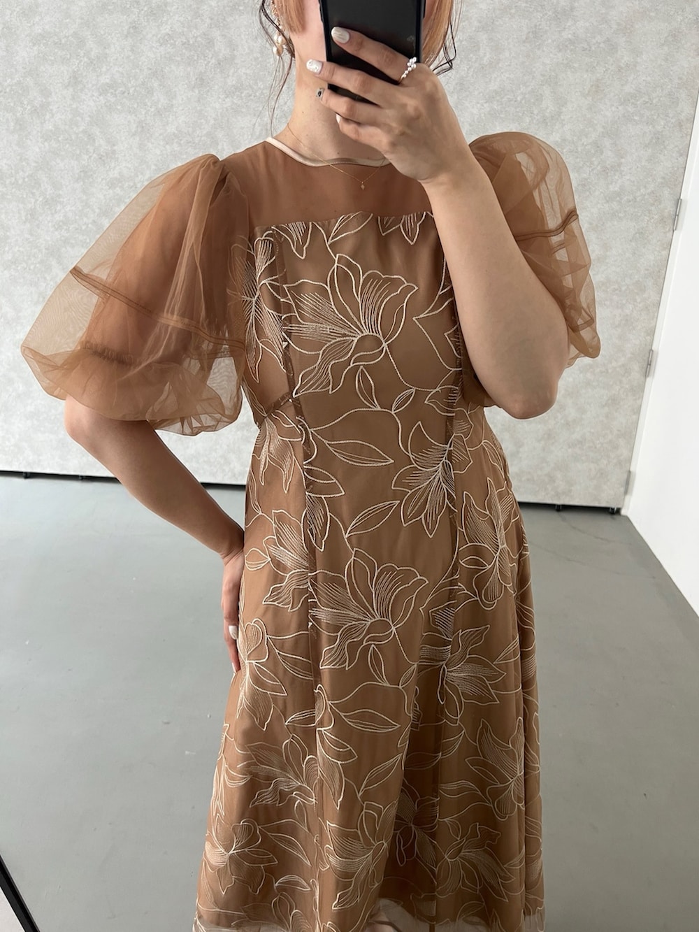 オレンジ系のドレス、ブラック系のパンプス、ブラック系のショルダーバッグを着用したレディースの春コーディネートの7枚目の写真