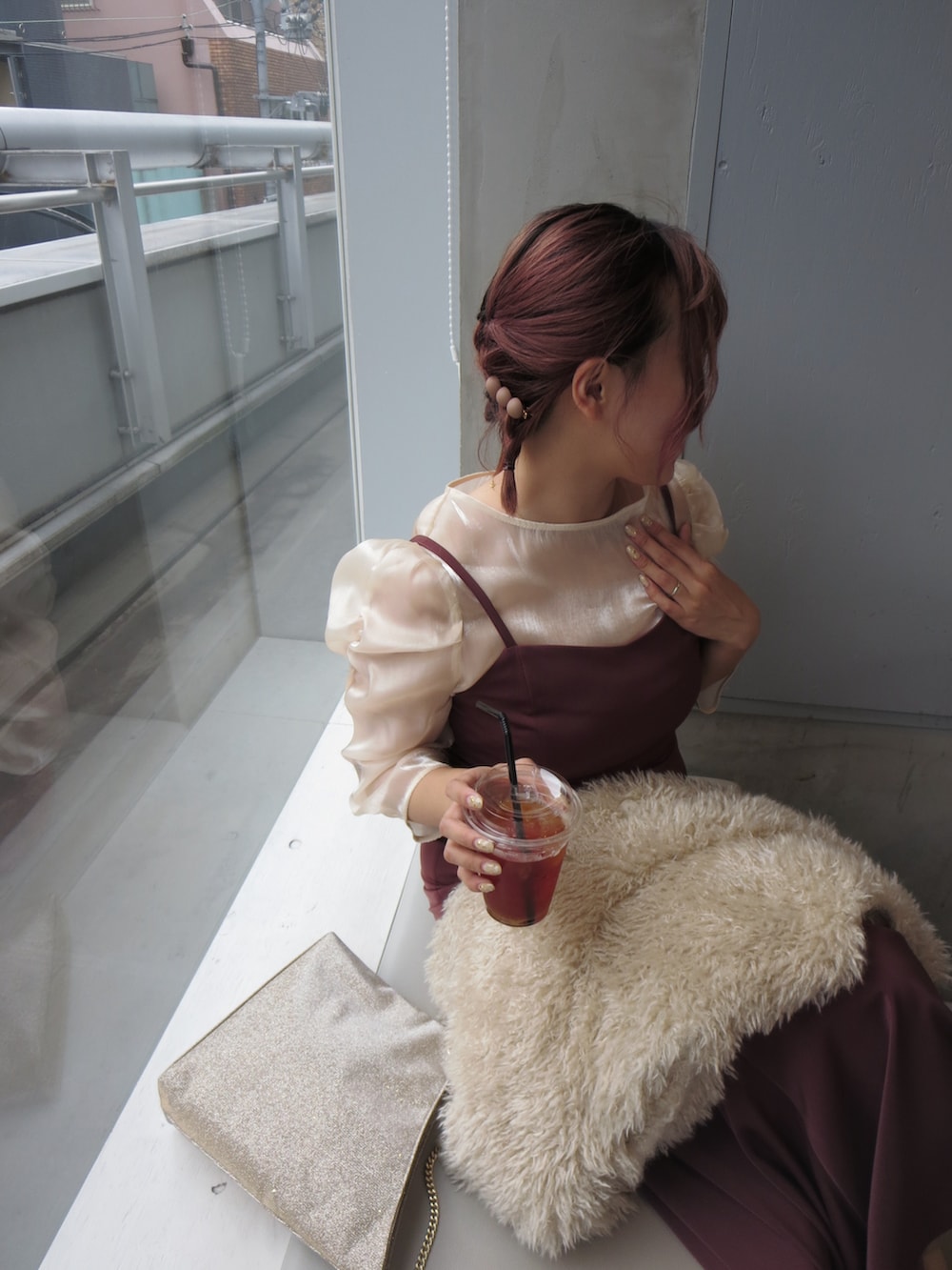 レッド系のドレス、ベージュ系のベスト、ベージュ系のブーツを着用したレディースの秋コーディネートの3枚目の写真