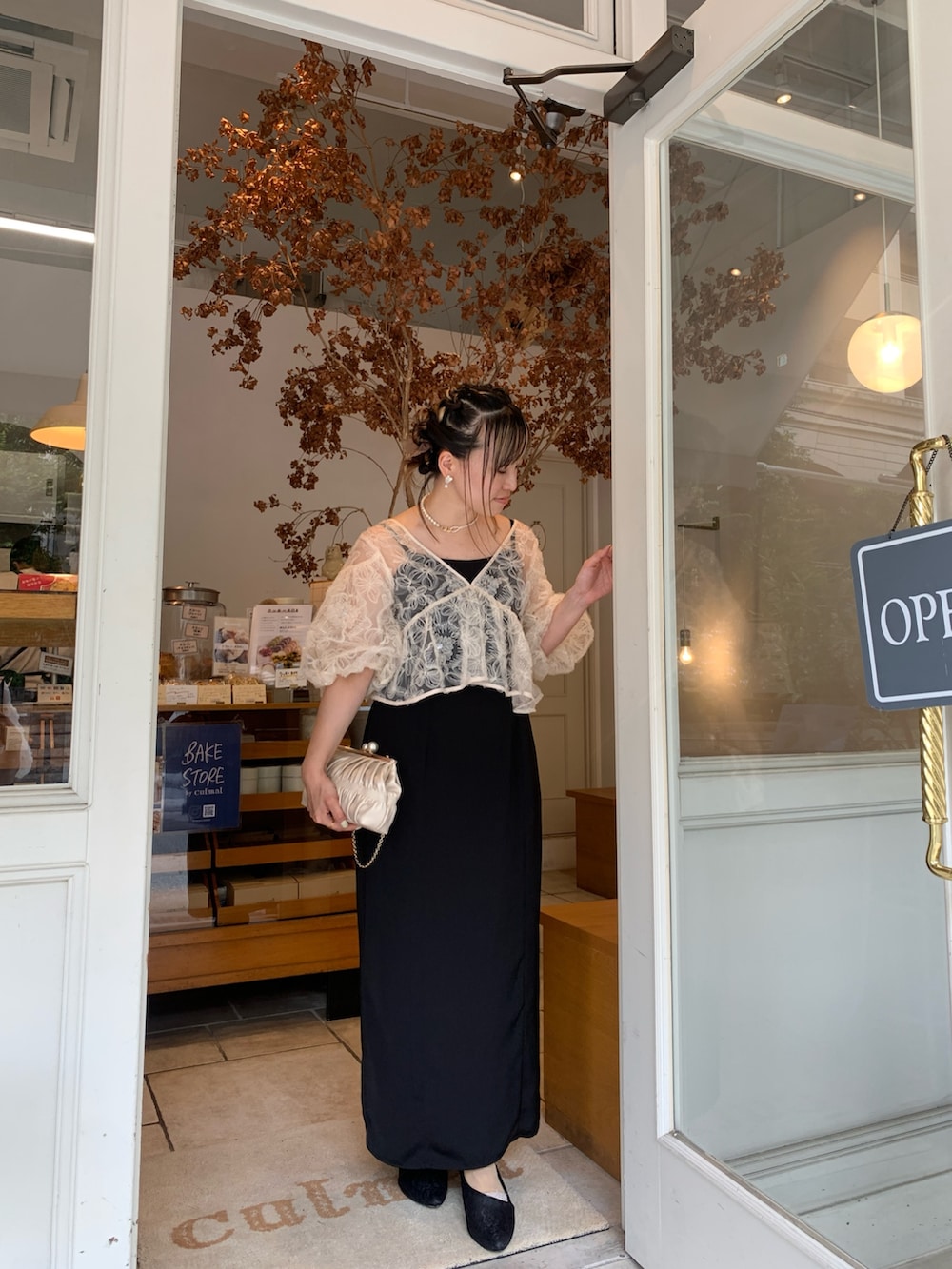 ベージュ系のドレス、ゴールド系のネックレスを着用したレディースの夏コーディネートの2枚目の写真