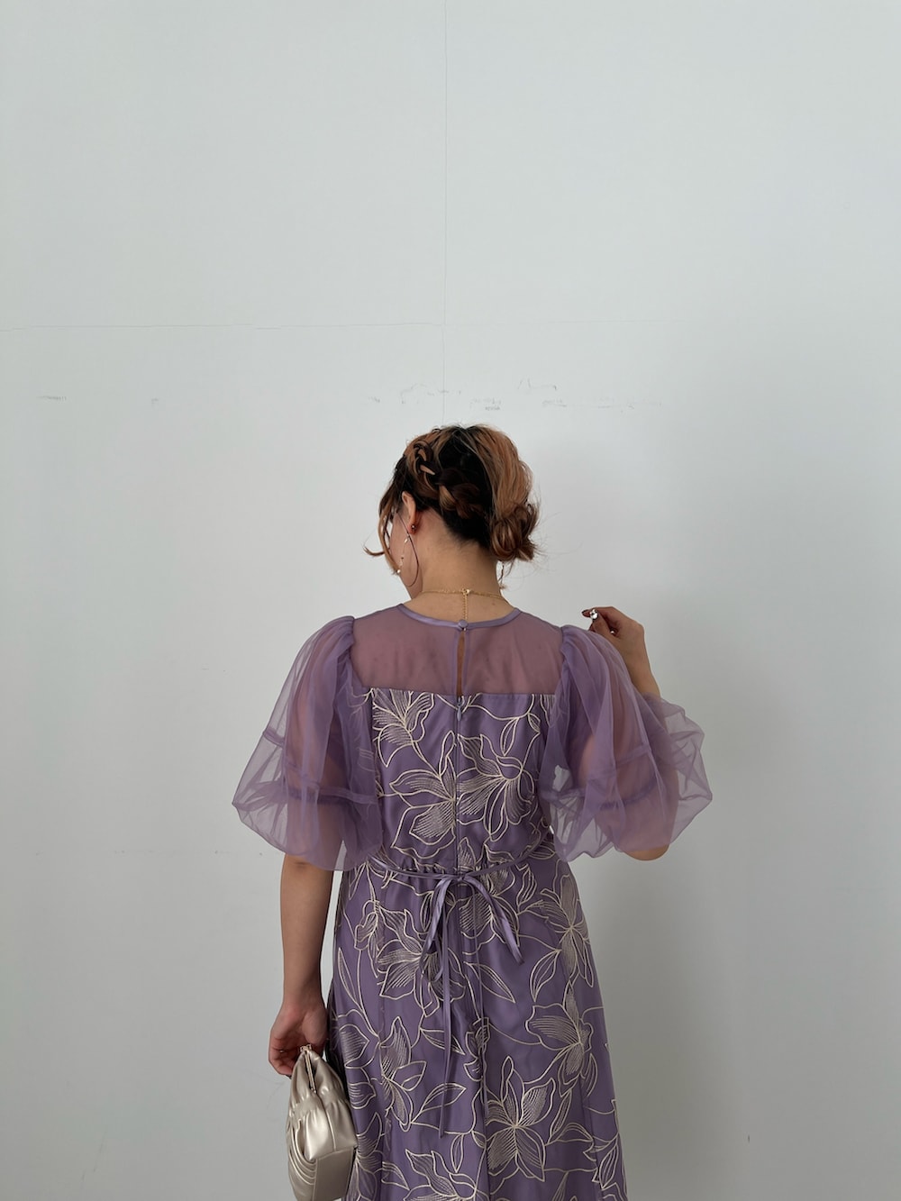 ゴールド系のバッグ、ベージュ系のシューズ、パープル系のドレスを着用したレディースの夏コーディネートの7枚目の写真