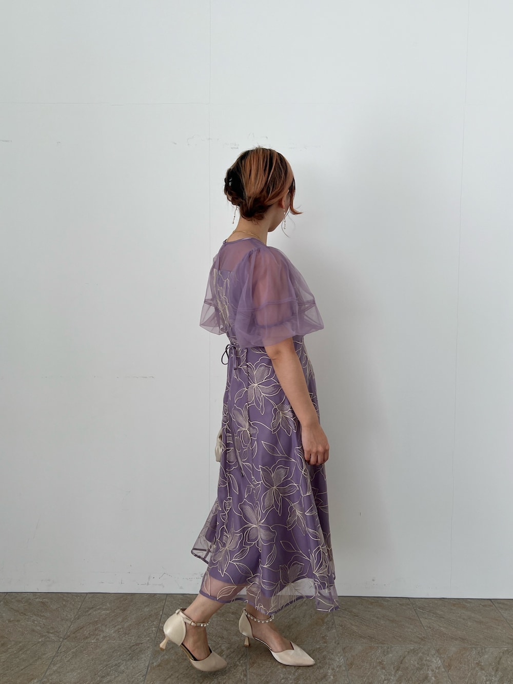 ゴールド系のバッグ、ベージュ系のシューズ、パープル系のドレスを着用したレディースの夏コーディネートの4枚目の写真