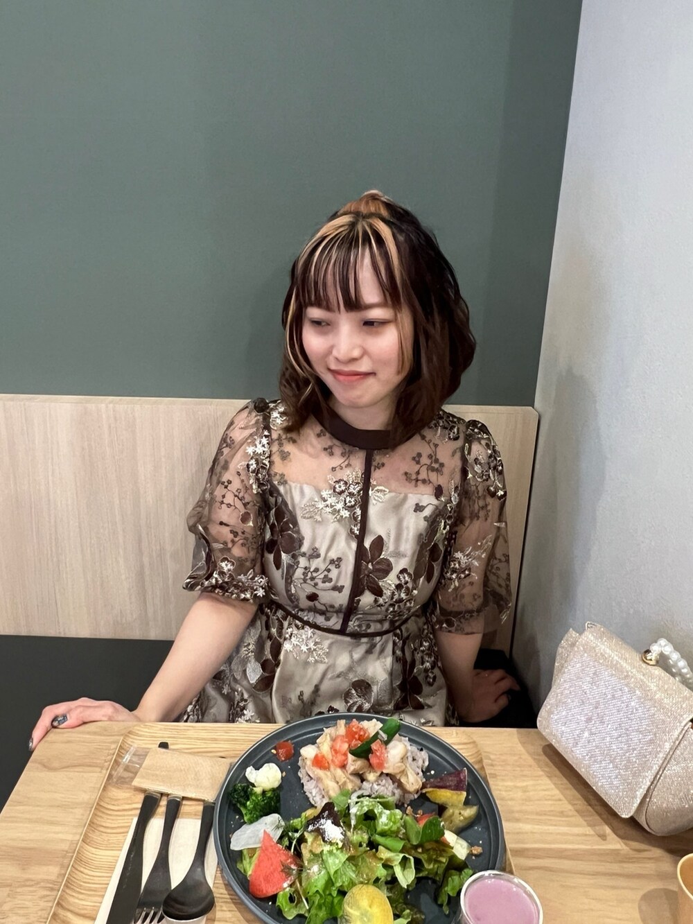 ブラウン系のドレス、ベージュ系のハンドバッグを着用したレディースの春コーディネートの7枚目の写真