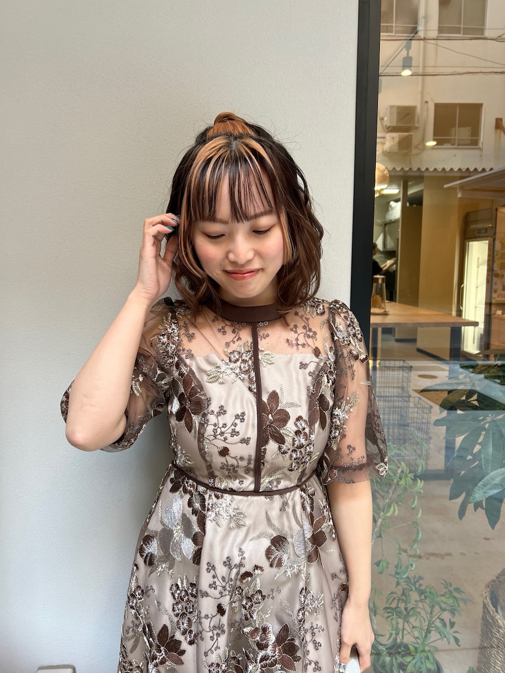 ブラウン系のドレス、ベージュ系のハンドバッグを着用したレディースの春コーディネートの4枚目の写真