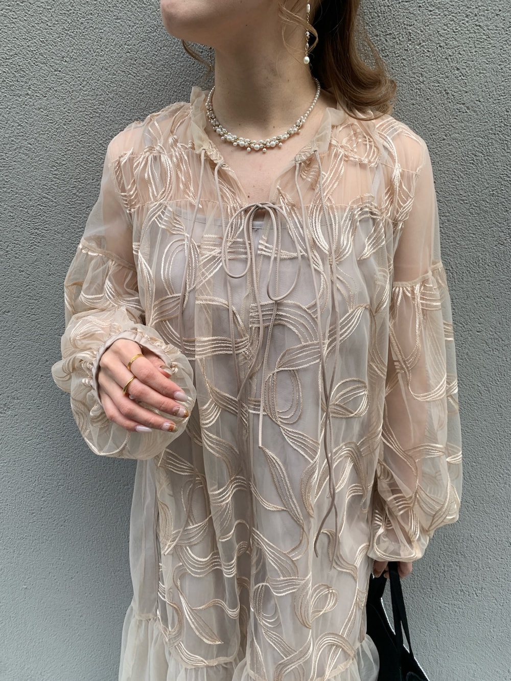 ピンク系のドレス、ホワイト系のネックレスを着用したレディースの春コーディネートの4枚目の写真