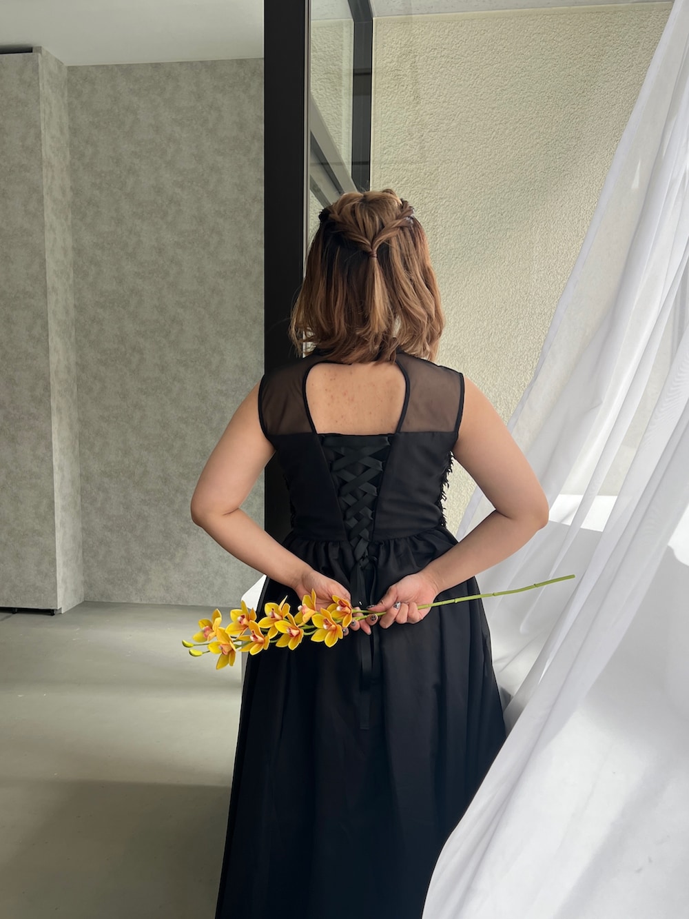 ブラック系のドレス、ブラック系のパンプスを着用したレディースの春コーディネートの6枚目の写真