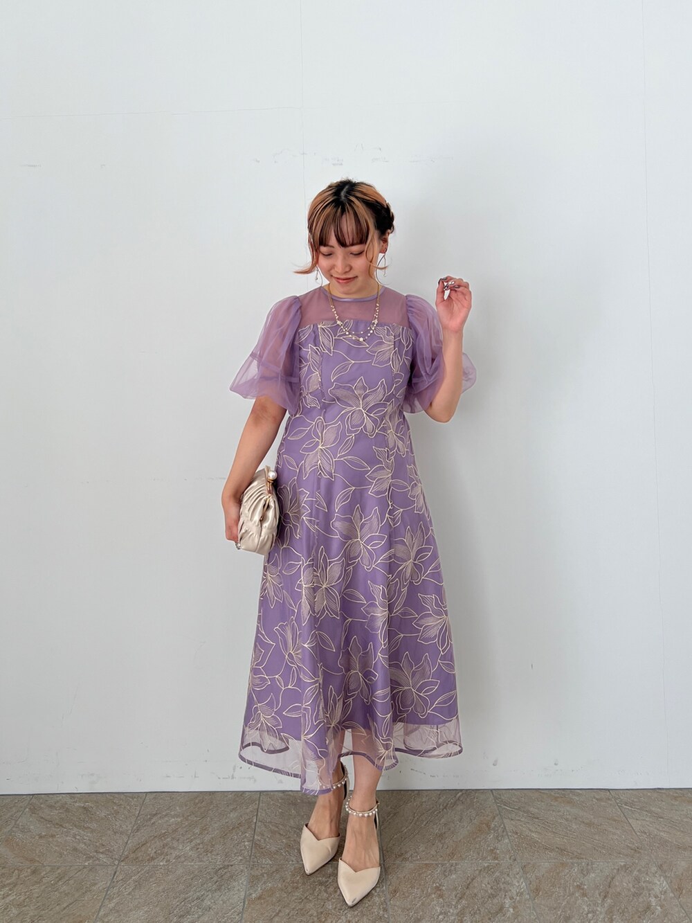 ゴールド系のバッグ、ベージュ系のシューズ、パープル系のドレスを着用したレディースの夏コーディネートの3枚目の写真