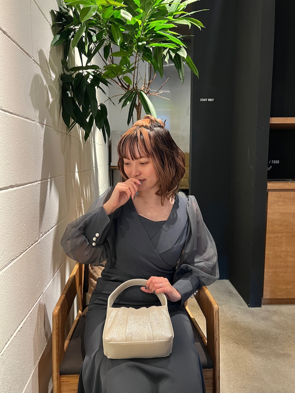 グリーン系のドレス、ベージュ系のハンドバッグ、ベージュ系のシューズを着用したレディースの春コーディネートの7枚目の写真