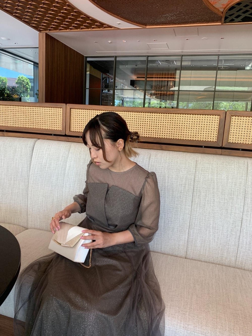 グリーン系のドレス、ベージュ系のクラッチバッグ、ベージュ系のパンプスを着用したレディースの夏コーディネートの2枚目の写真