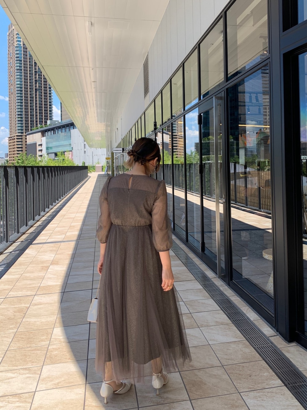 グリーン系のドレス、ベージュ系のクラッチバッグ、ベージュ系のパンプスを着用したレディースの夏コーディネートの4枚目の写真