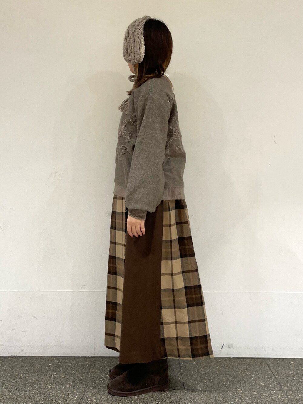 ホワイト系のTシャツ/カットソー、ブラウン系のカーディガン/ボレロ、ブラウン系のブーツを着用したレディースの冬コーディネートの3枚目の写真