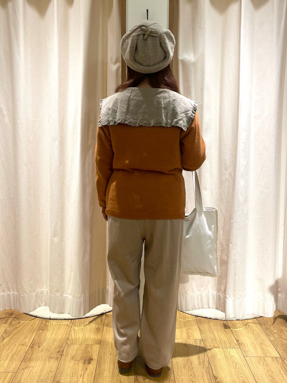 ベージュ系のチュニック、オレンジ系のカーディガン/ボレロ、ホワイト系のトートバッグを着用したレディースの秋コーディネートの3枚目の写真