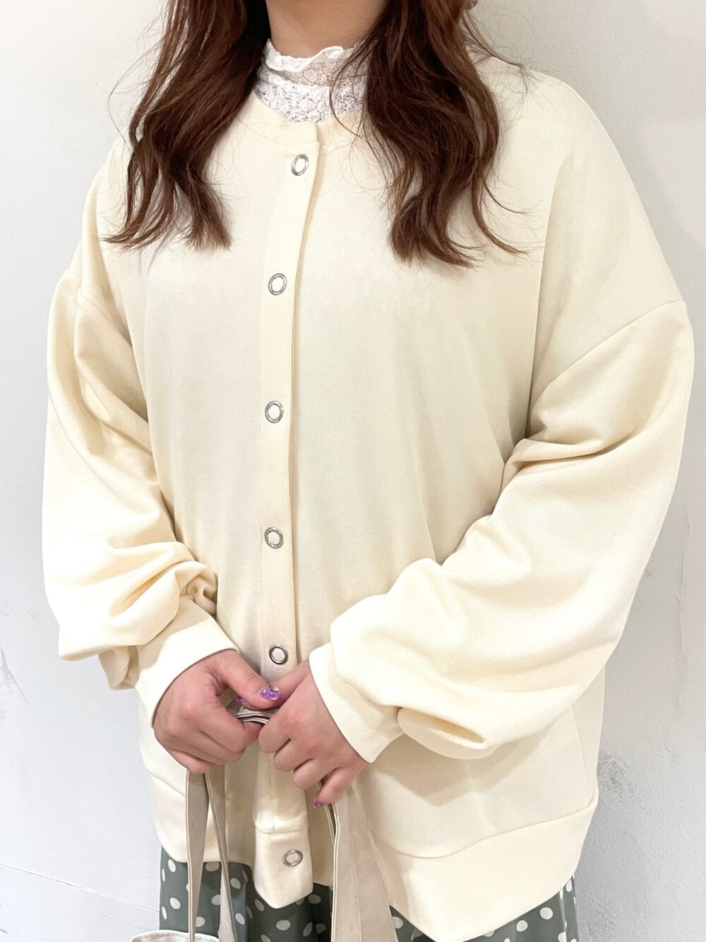 ホワイト系のTシャツ/カットソー、ホワイト系のカーディガン/ボレロ、ベージュ系のハンドバッグを着用したレディースの冬コーディネートの5枚目の写真