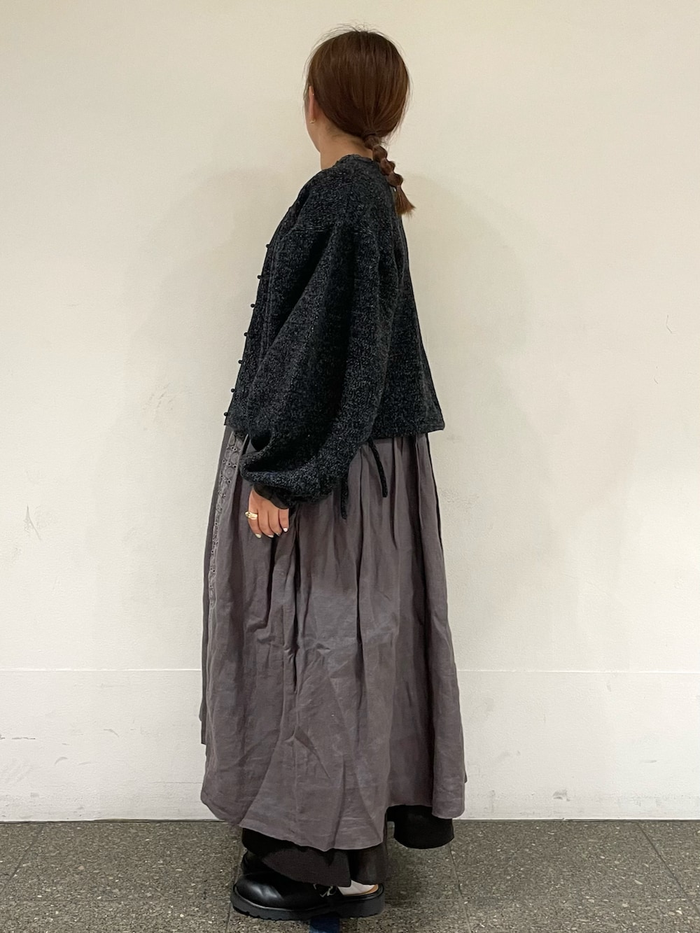 ブラック系のカーディガン/ボレロ、グレー系のスカート、ブラック系のサンダルを着用したレディースの秋コーディネートの3枚目の写真