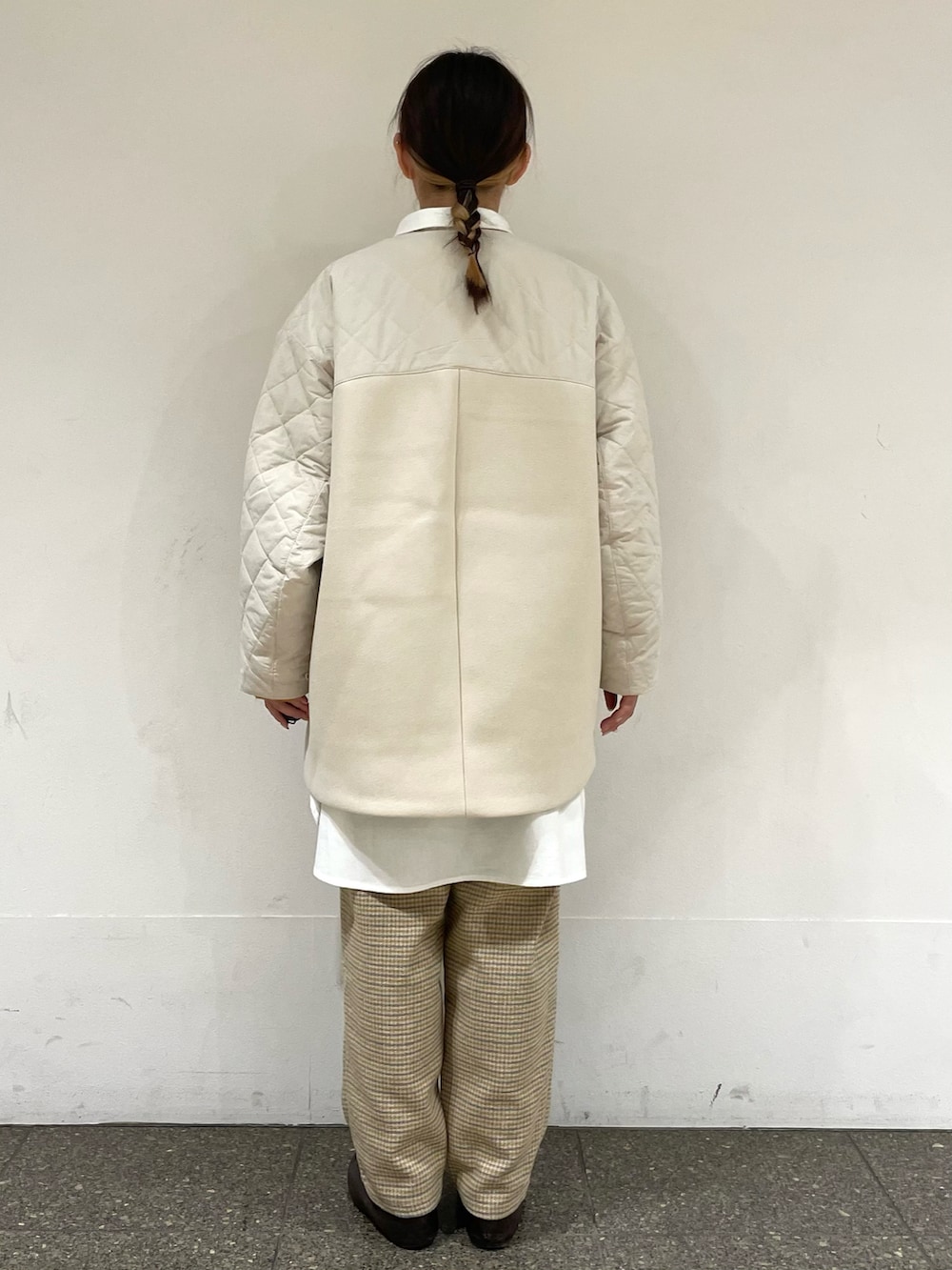 ブラウン系のドレスシューズ、ホワイト系のチュニック、ホワイト系のブルゾンを着用したレディースの冬コーディネートの4枚目の写真