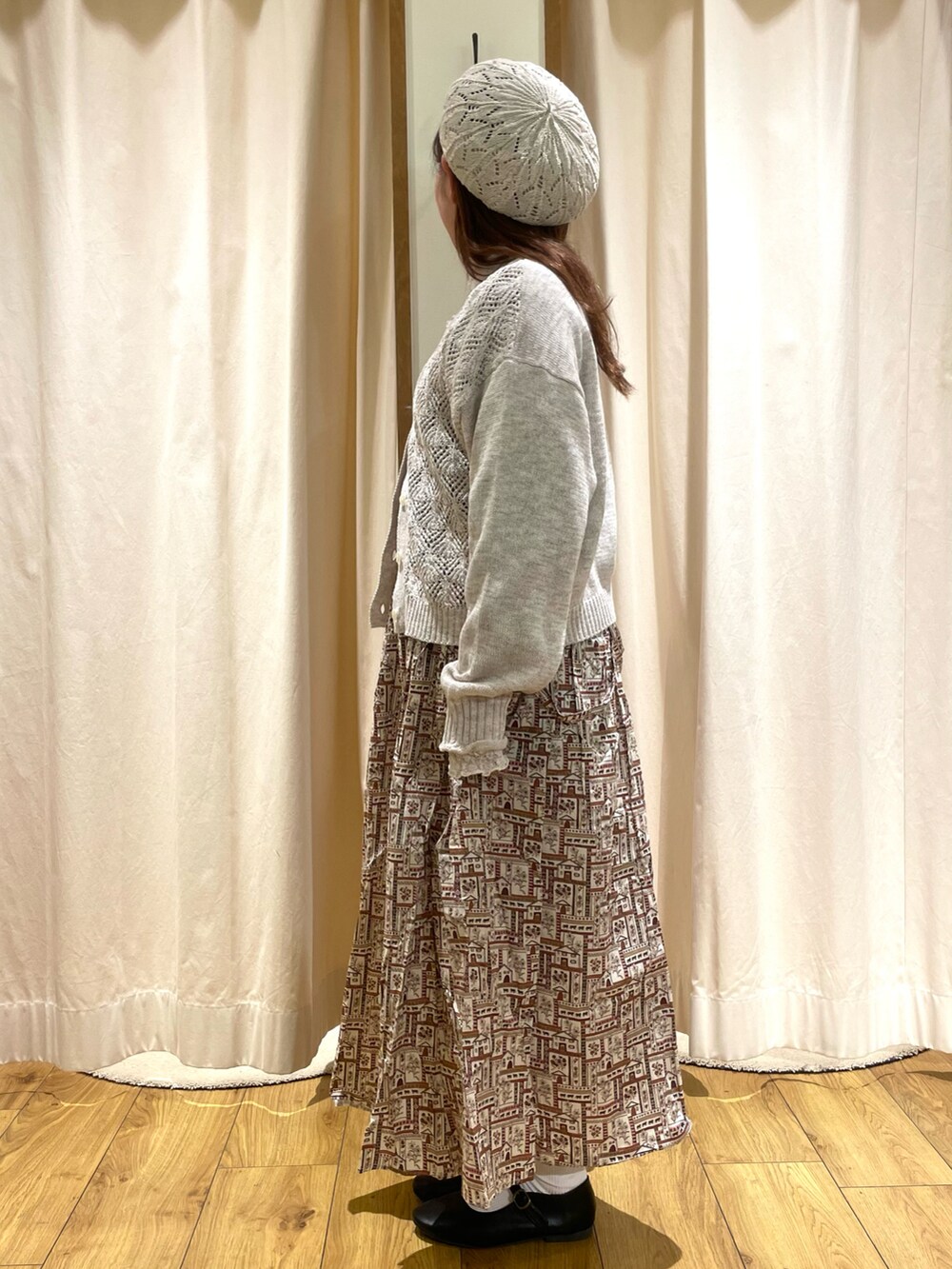 ホワイト系のカーディガン/ボレロ、レッド系のシャツ/ブラウス、レッド系のスカートを着用したレディースの冬コーディネートの2枚目の写真