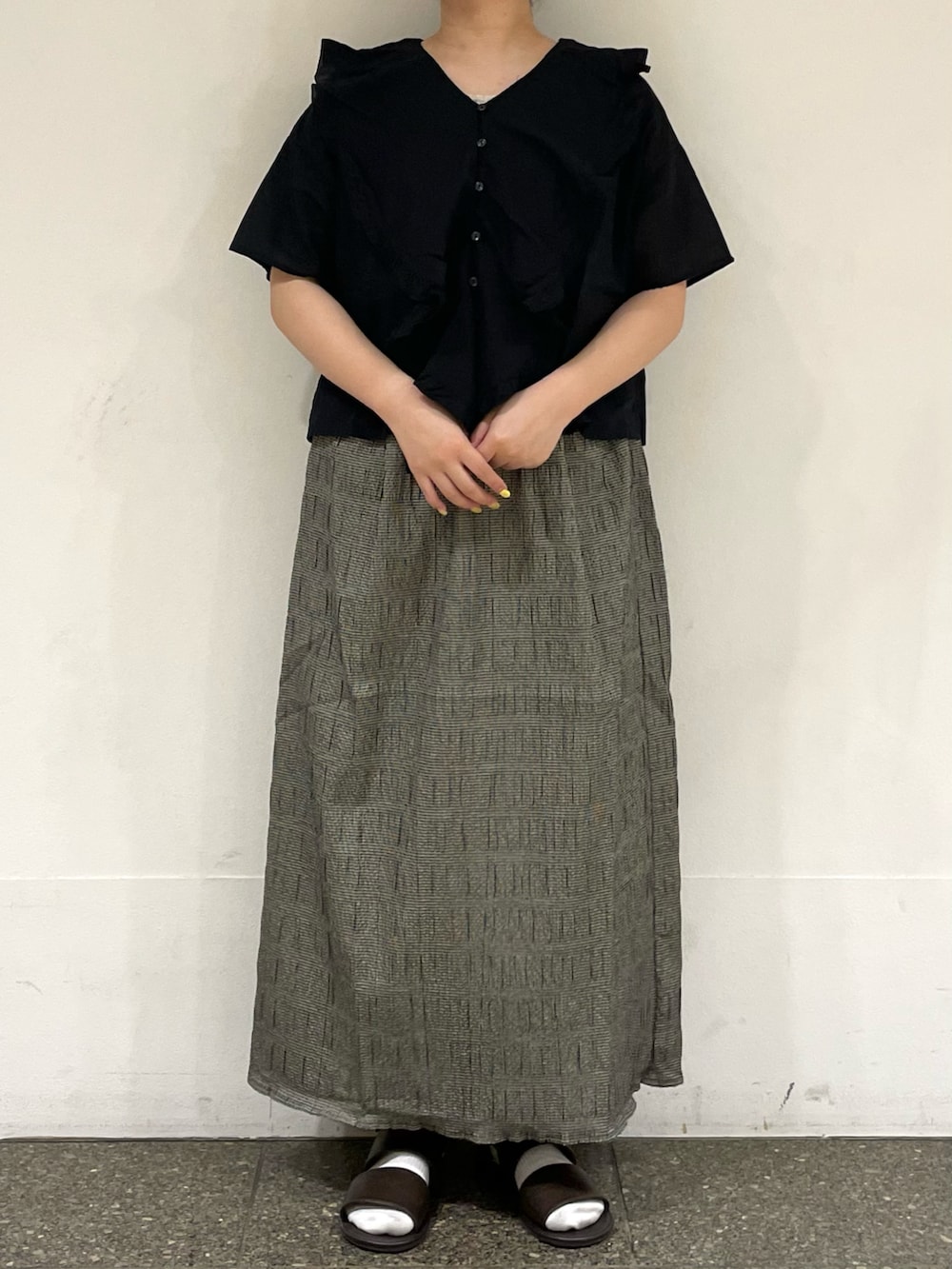 ブラウン系のサンダル、ブラック系のシャツ/ブラウス、ブラック系のスカートを着用したレディースの秋コーディネートの2枚目の写真