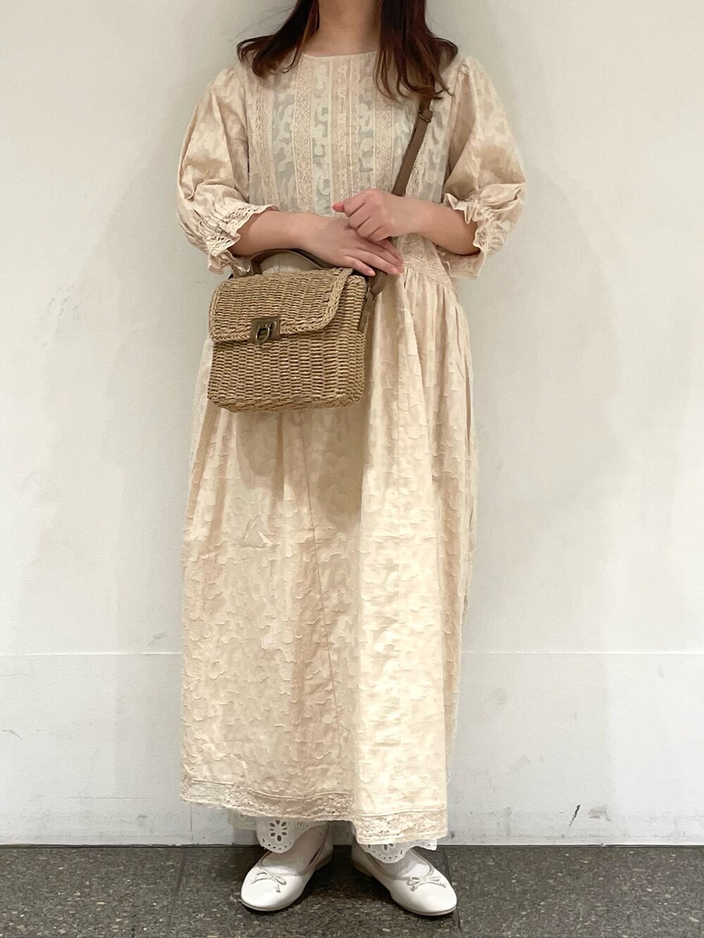 ホワイト系のパンプス、ホワイト系のワンピース、ベージュ系のハンドバッグを着用したレディースの春コーディネートの2枚目の写真