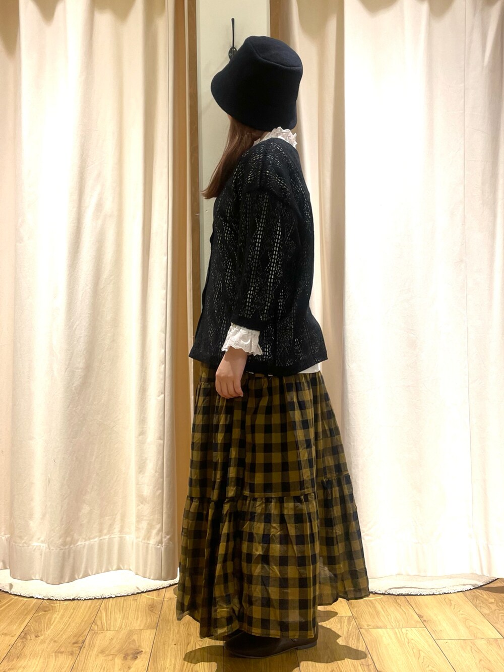 ホワイト系のTシャツ/カットソー、ブラック系のカーディガン/ボレロ、イエロー系のスカートを着用したレディースの夏コーディネートの2枚目の写真