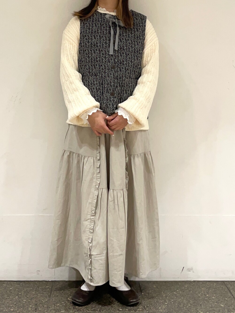 ブラウン系のドレスシューズ、ホワイト系のシャツ/ブラウス、グリーン系のベストを着用したレディースの冬コーディネートの2枚目の写真