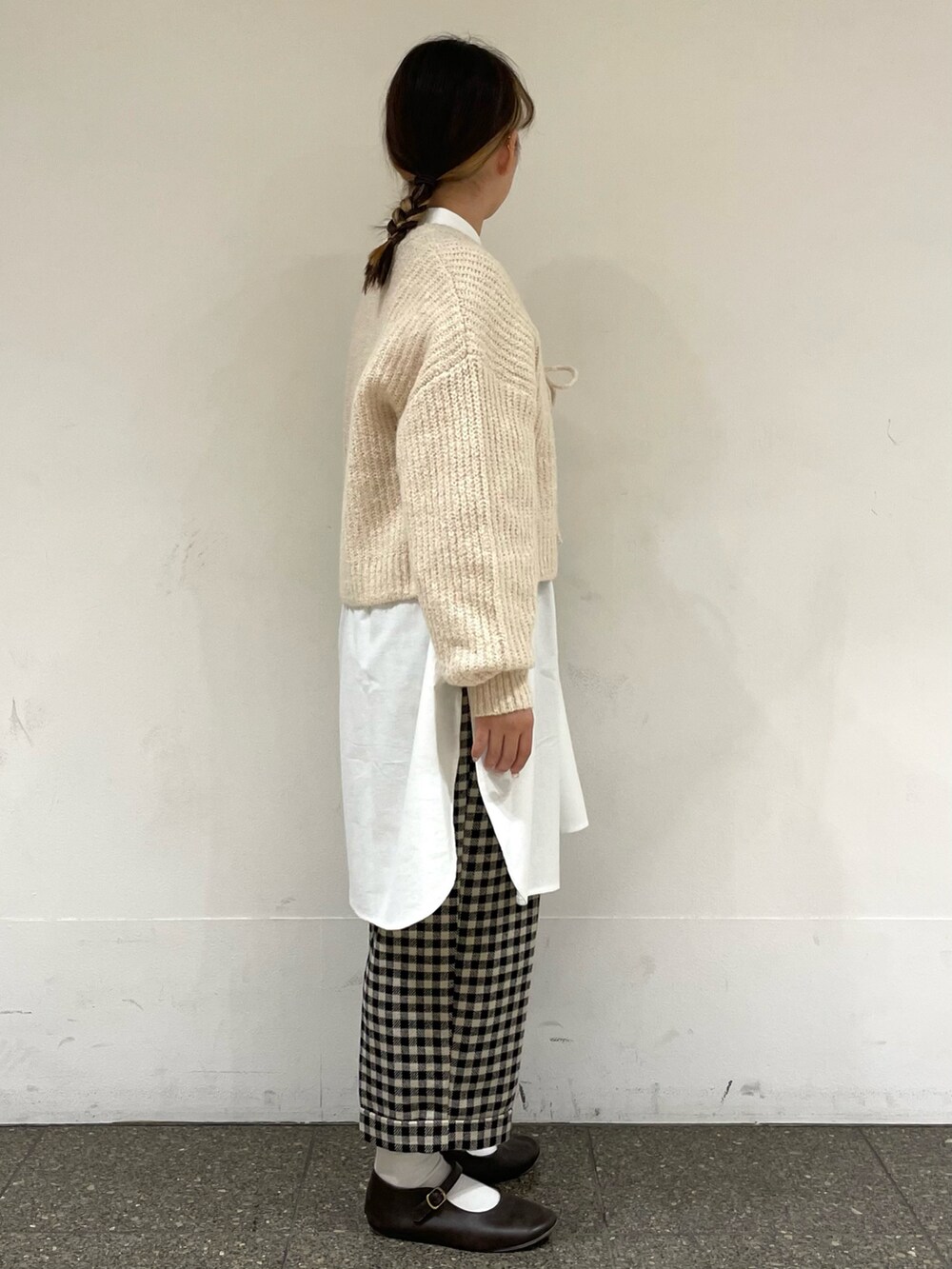 ホワイト系のチュニック、ブラウン系のドレスシューズ、ホワイト系のカーディガン/ボレロを着用したレディースの冬コーディネートの5枚目の写真