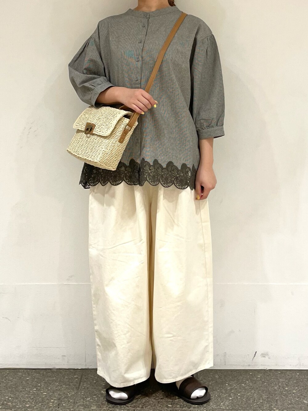 ブラウン系のサンダル、グレー系のシャツ/ブラウス、ホワイト系のハンドバッグを着用したレディースの夏コーディネートの2枚目の写真