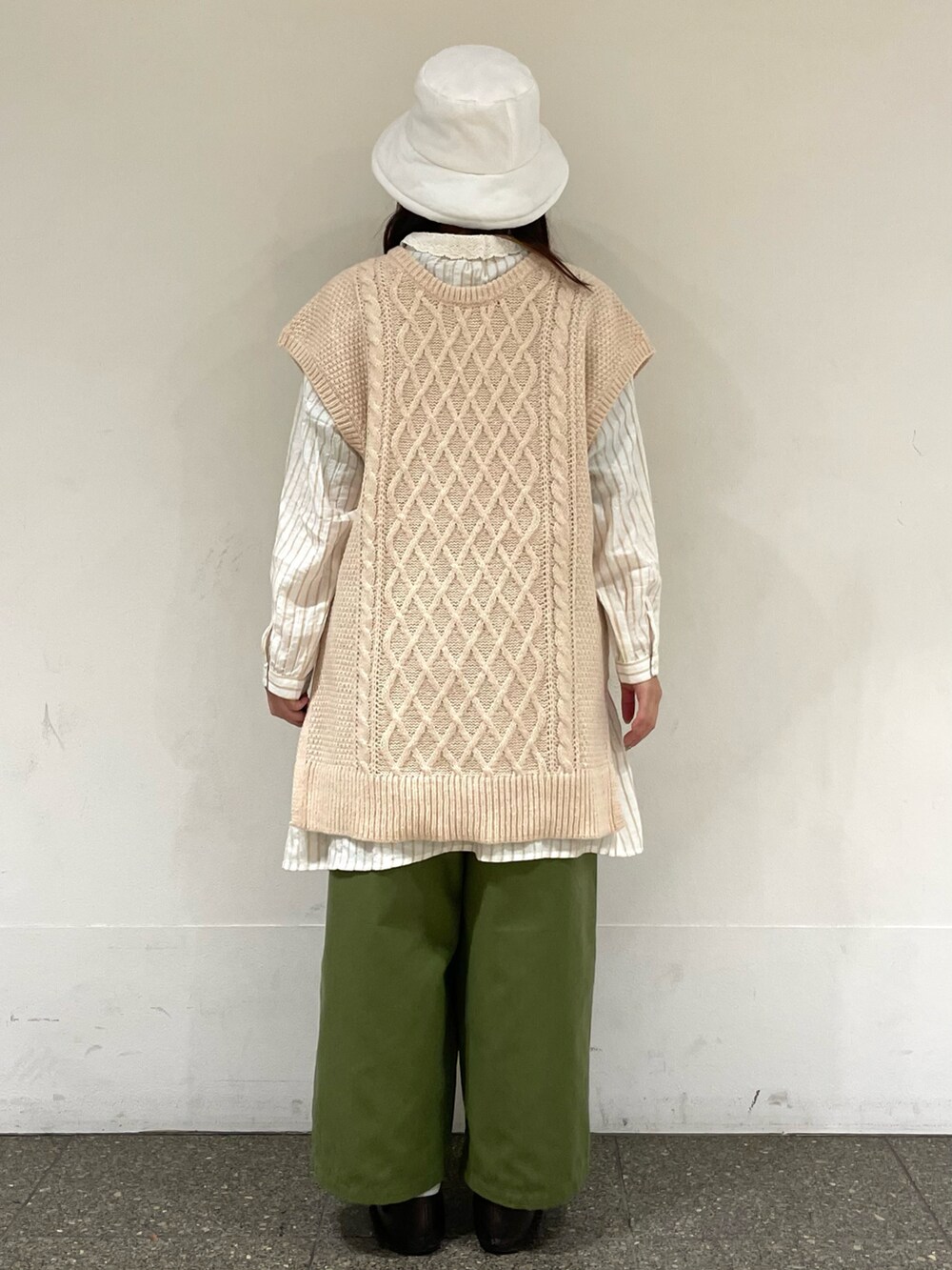 ブラウン系のドレスシューズ、ホワイト系のベスト、ベージュ系のチュニックを着用したレディースの冬コーディネートの4枚目の写真