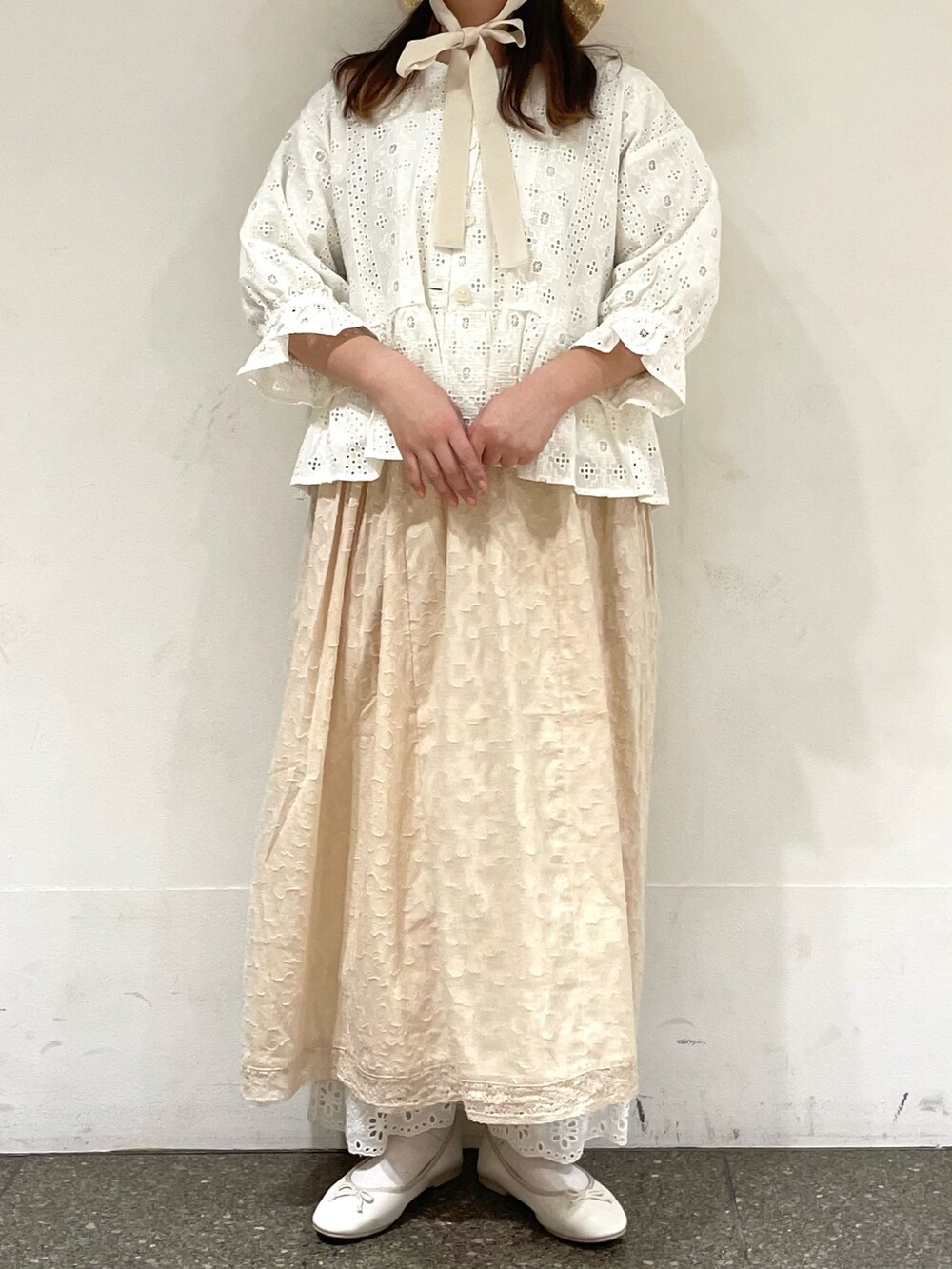 ホワイト系のパンプス、ホワイト系のノーカラージャケット、ホワイト系のワンピースを着用したレディースの春コーディネートの2枚目の写真