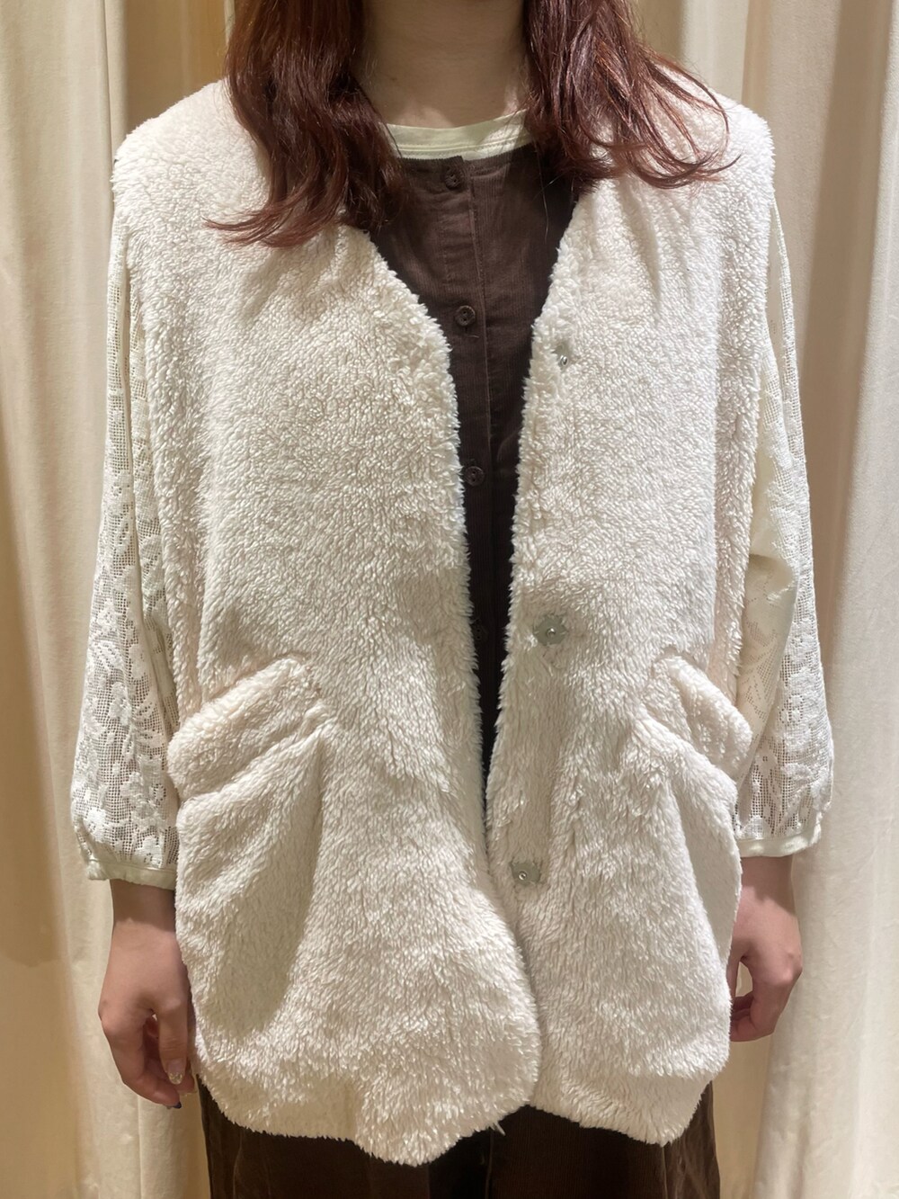 ホワイト系のTシャツ/カットソー、ホワイト系のベスト、ブラウン系のジャンパースカートを着用したレディースの秋コーディネートの5枚目の写真