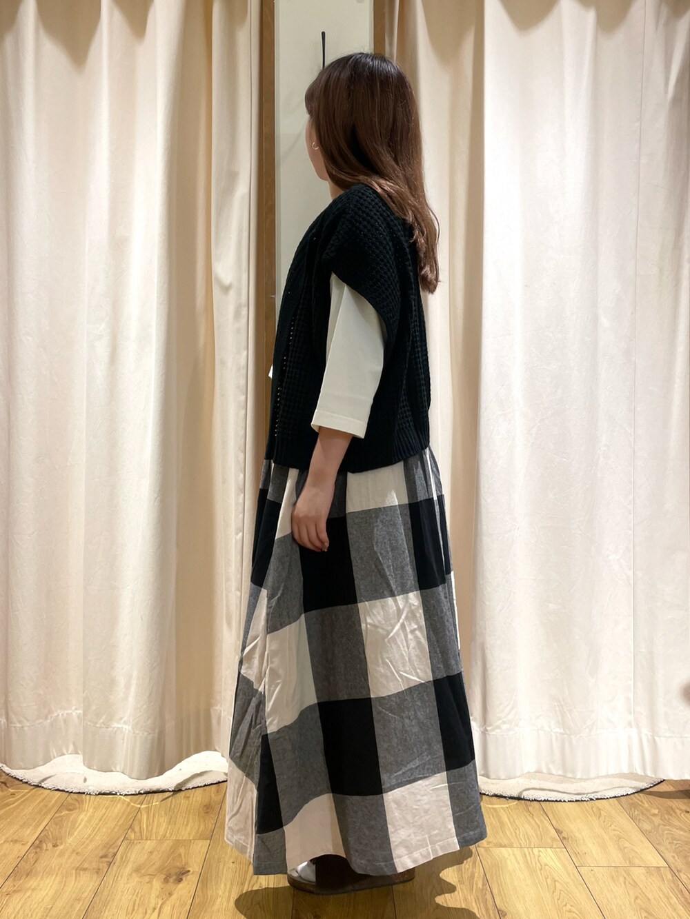 ホワイト系のTシャツ/カットソー、ブラック系のベスト、ブラック系のスカートを着用したレディースの夏コーディネートの2枚目の写真