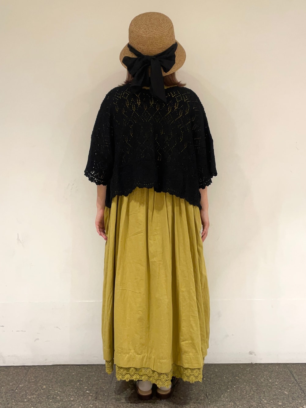 ブラック系のカーディガン/ボレロ、グリーン系のワンピース、ブラック系のサンダルを着用したレディースの春コーディネートの4枚目の写真