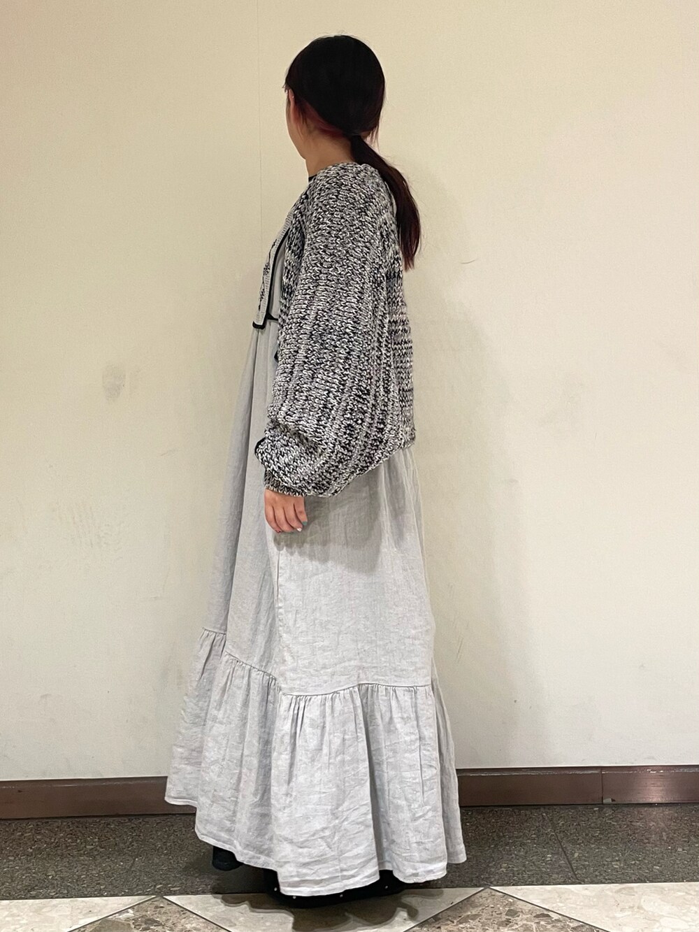 グレー系のワンピース、グレー系のドレスシューズ、ブラック系のカーディガン/ボレロを着用したレディースの冬コーディネートの3枚目の写真