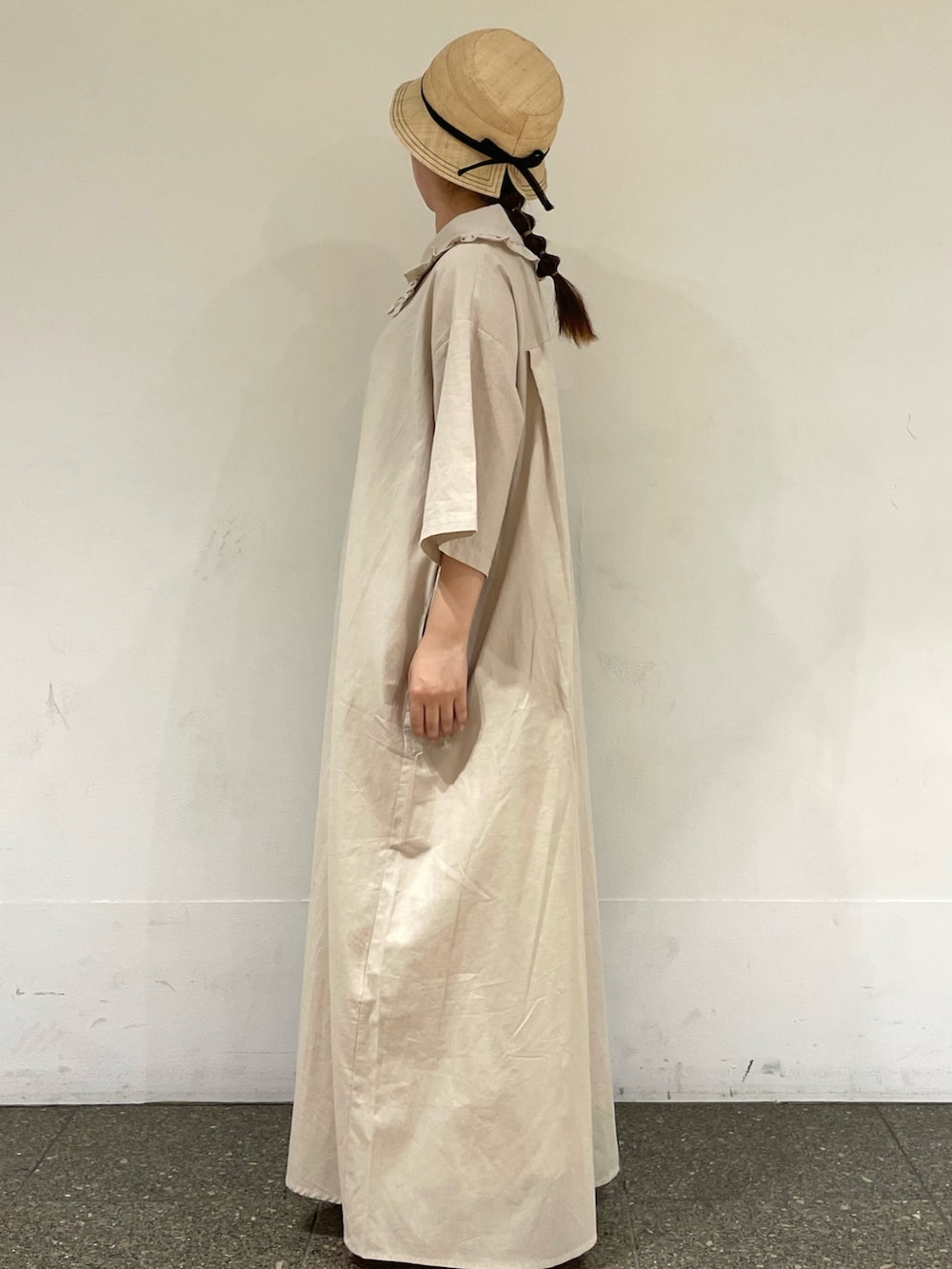 ベージュ系のワンピース、ブラック系のハットを着用したレディースの秋コーディネートの3枚目の写真