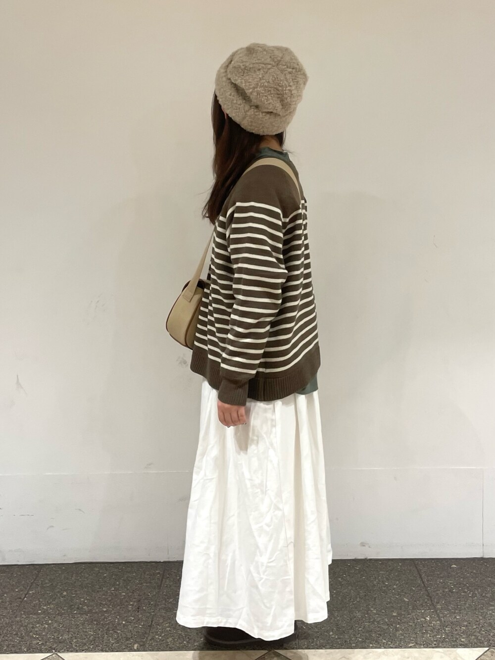 グリーン系のシャツ/ブラウス、ブラウン系のニット/セーター、ベージュ系のショルダーバッグを着用したレディースの冬コーディネートの2枚目の写真