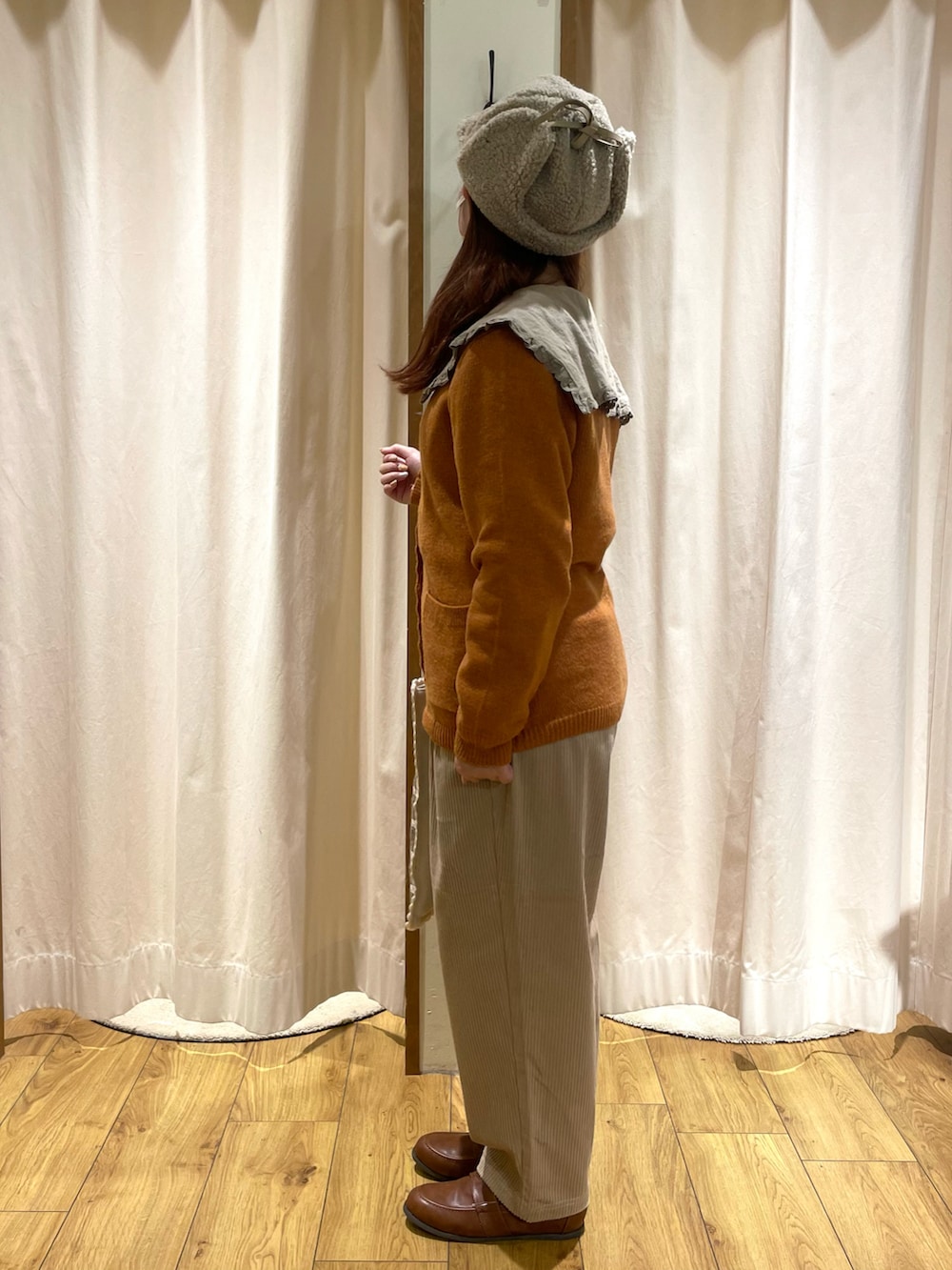 ベージュ系のチュニック、オレンジ系のカーディガン/ボレロ、ホワイト系のトートバッグを着用したレディースの秋コーディネートの2枚目の写真