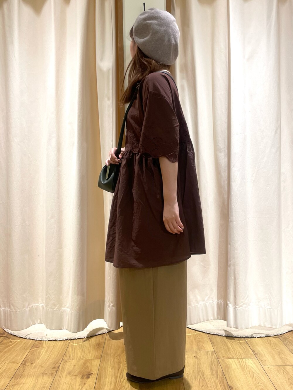 ブラウン系のチュニック、グリーン系のハンドバッグ、ベージュ系のその他パンツを着用したレディースの夏コーディネートの2枚目の写真