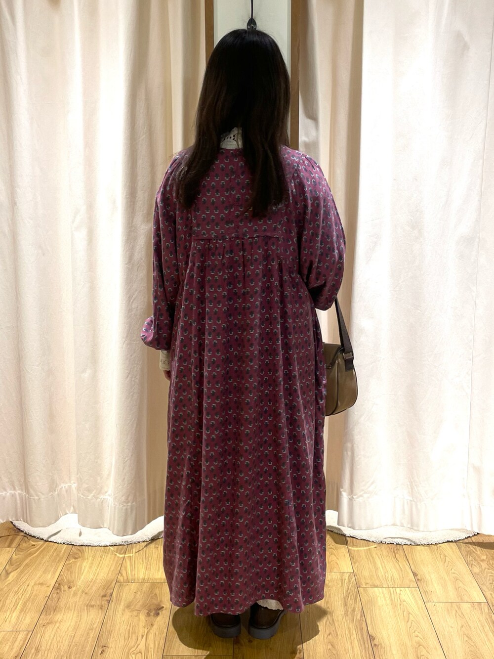 ホワイト系のTシャツ/カットソー、レッド系のワンピース、ブラウン系のショルダーバッグを着用したレディースの冬コーディネートの3枚目の写真