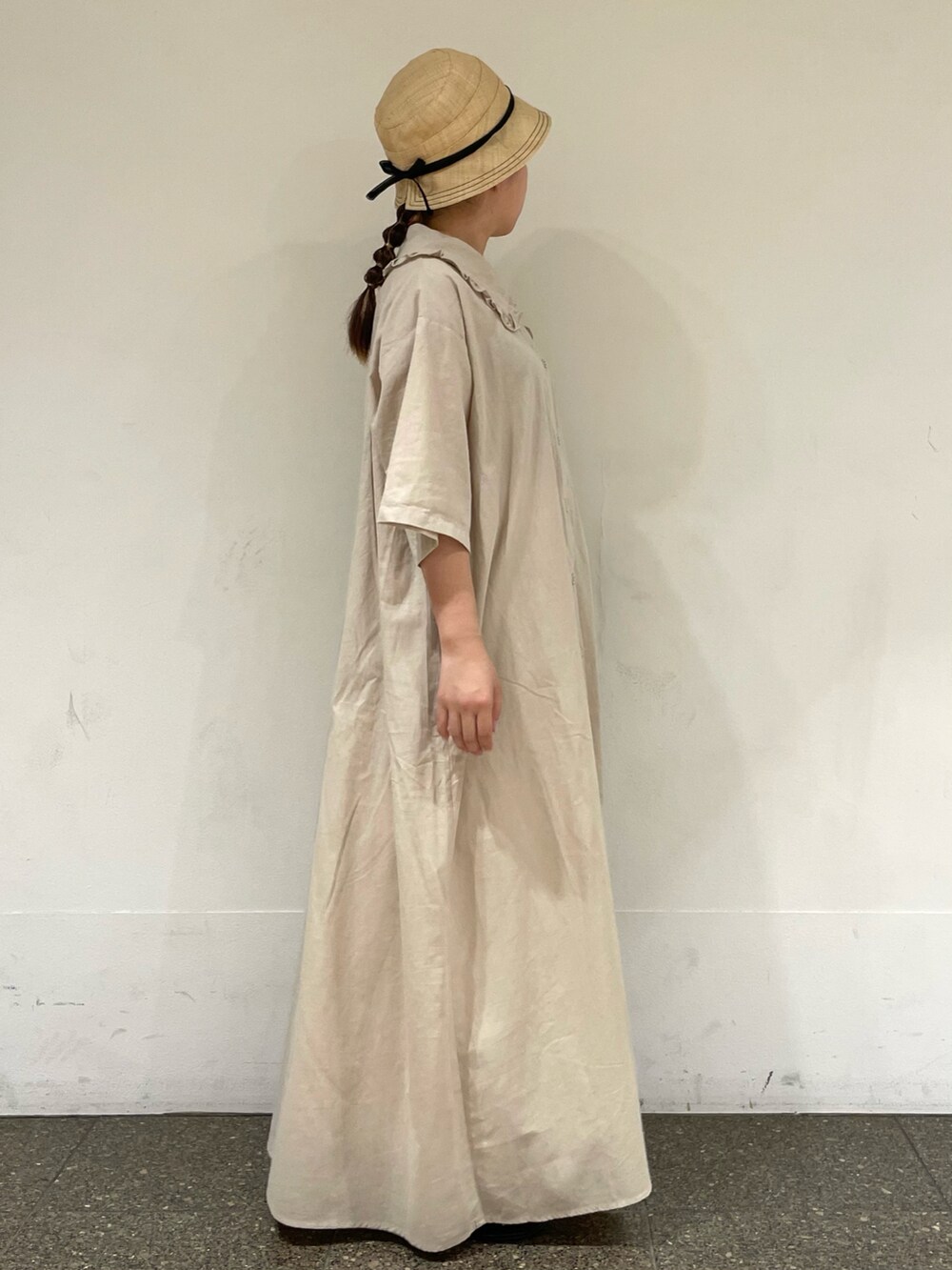 ベージュ系のワンピース、ブラック系のハットを着用したレディースの秋コーディネートの5枚目の写真