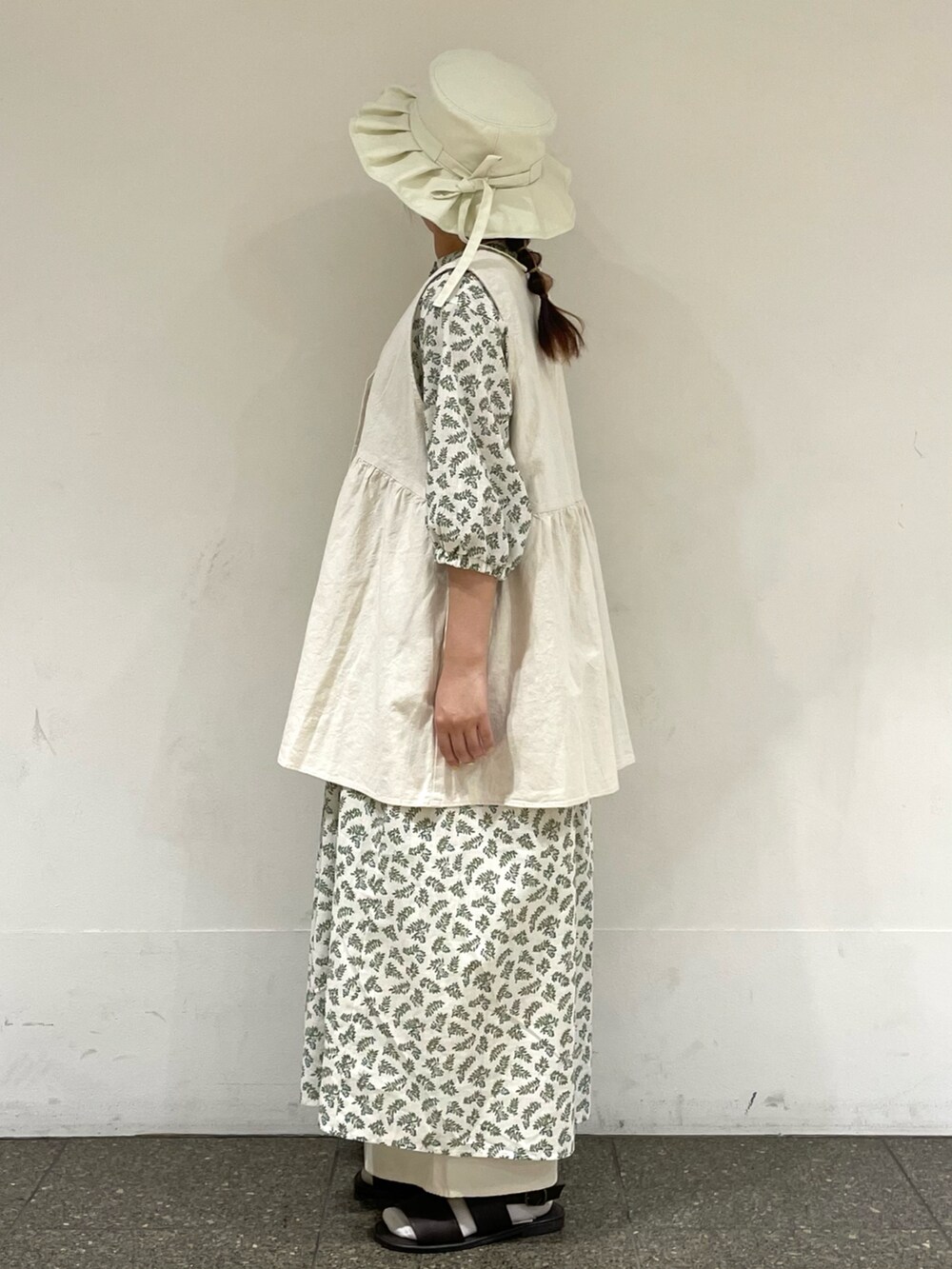 ブラウン系のサンダル、ホワイト系のワンピース、ホワイト系のベストを着用したレディースの秋コーディネートの3枚目の写真