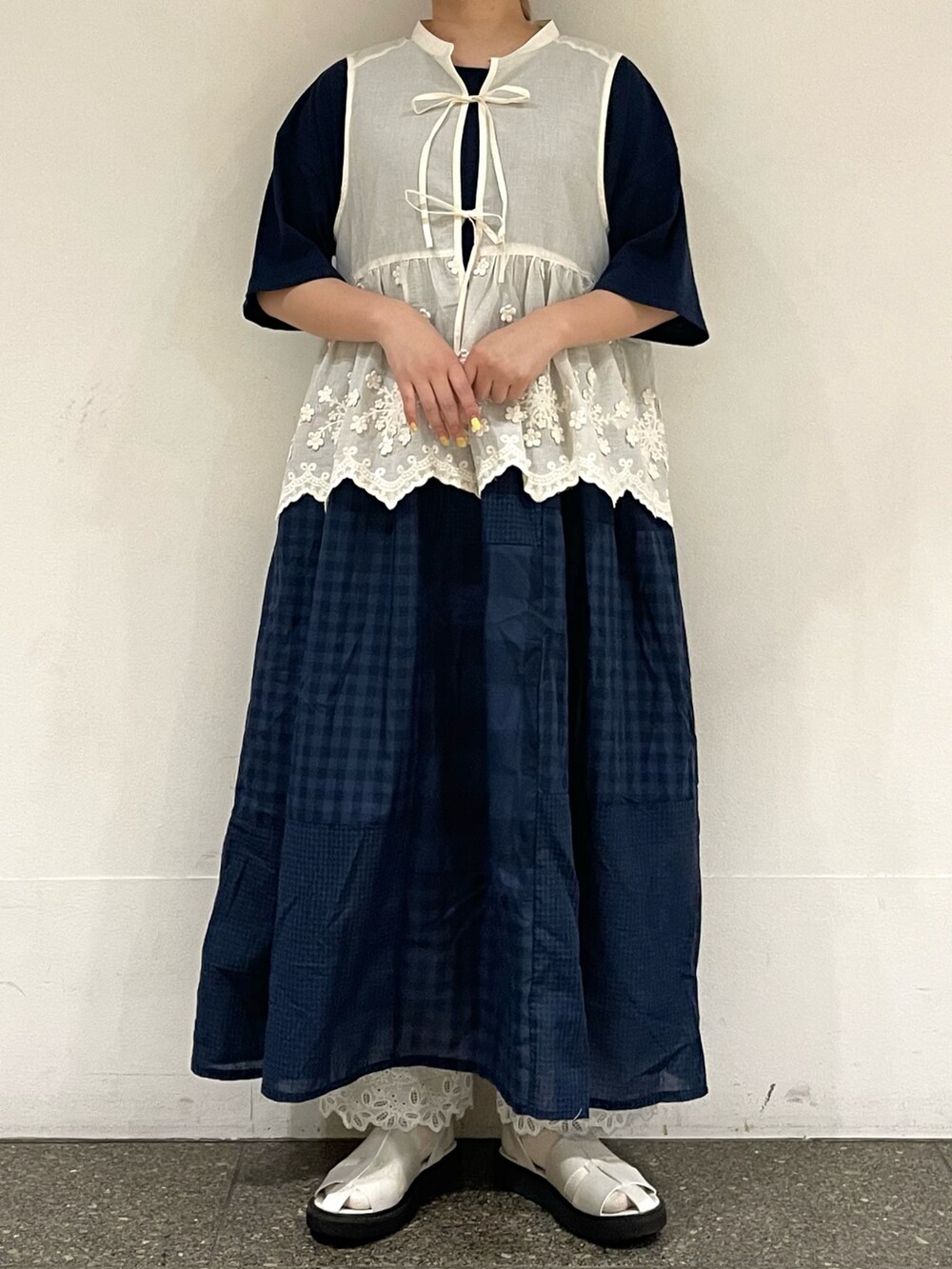 ホワイト系のサンダル、ホワイト系のベスト、ブルー系のワンピースを着用したレディースの秋コーディネートの2枚目の写真