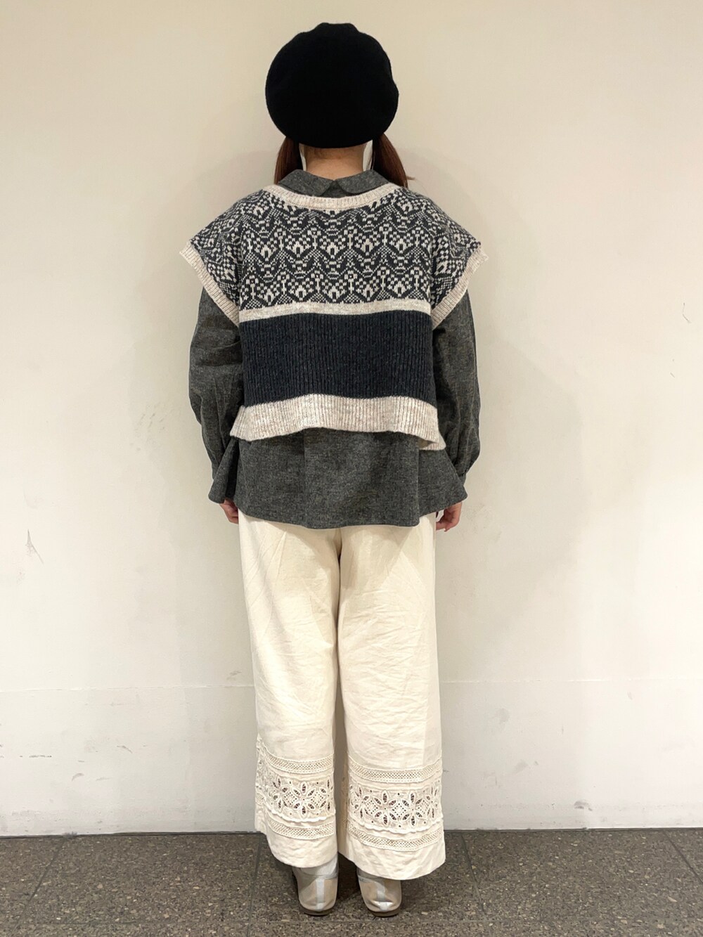 グレー系のシャツ/ブラウス、グレー系のベスト、ホワイト系のその他パンツを着用したレディースの冬コーディネートの4枚目の写真