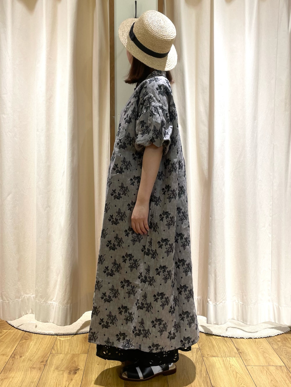 グレー系のワンピース、ブラック系のスカート、ブラック系のサンダルを着用したレディースの春コーディネートの2枚目の写真