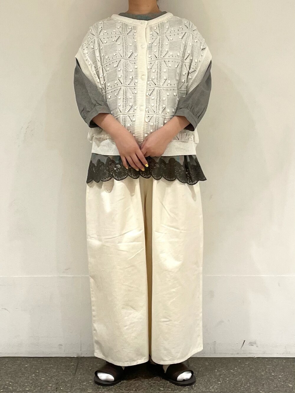 ブラウン系のサンダル、グレー系のシャツ/ブラウス、ホワイト系のベストを着用したレディースの夏コーディネートの2枚目の写真