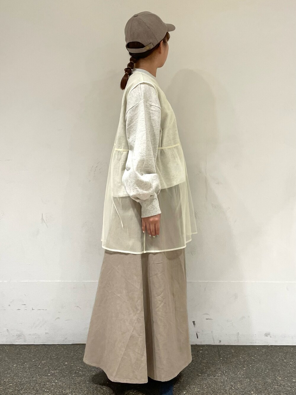 グレー系のTシャツ/カットソー、ホワイト系のベスト、ベージュ系のスカートを着用したレディースの秋コーディネートの5枚目の写真