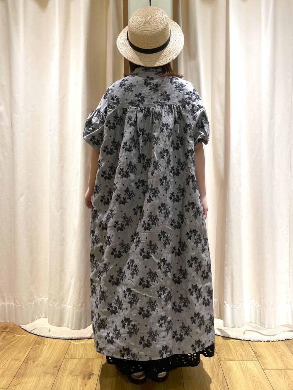 グレー系のワンピース、ブラック系のスカート、ブラック系のサンダルを着用したレディースの春コーディネートの3枚目の写真