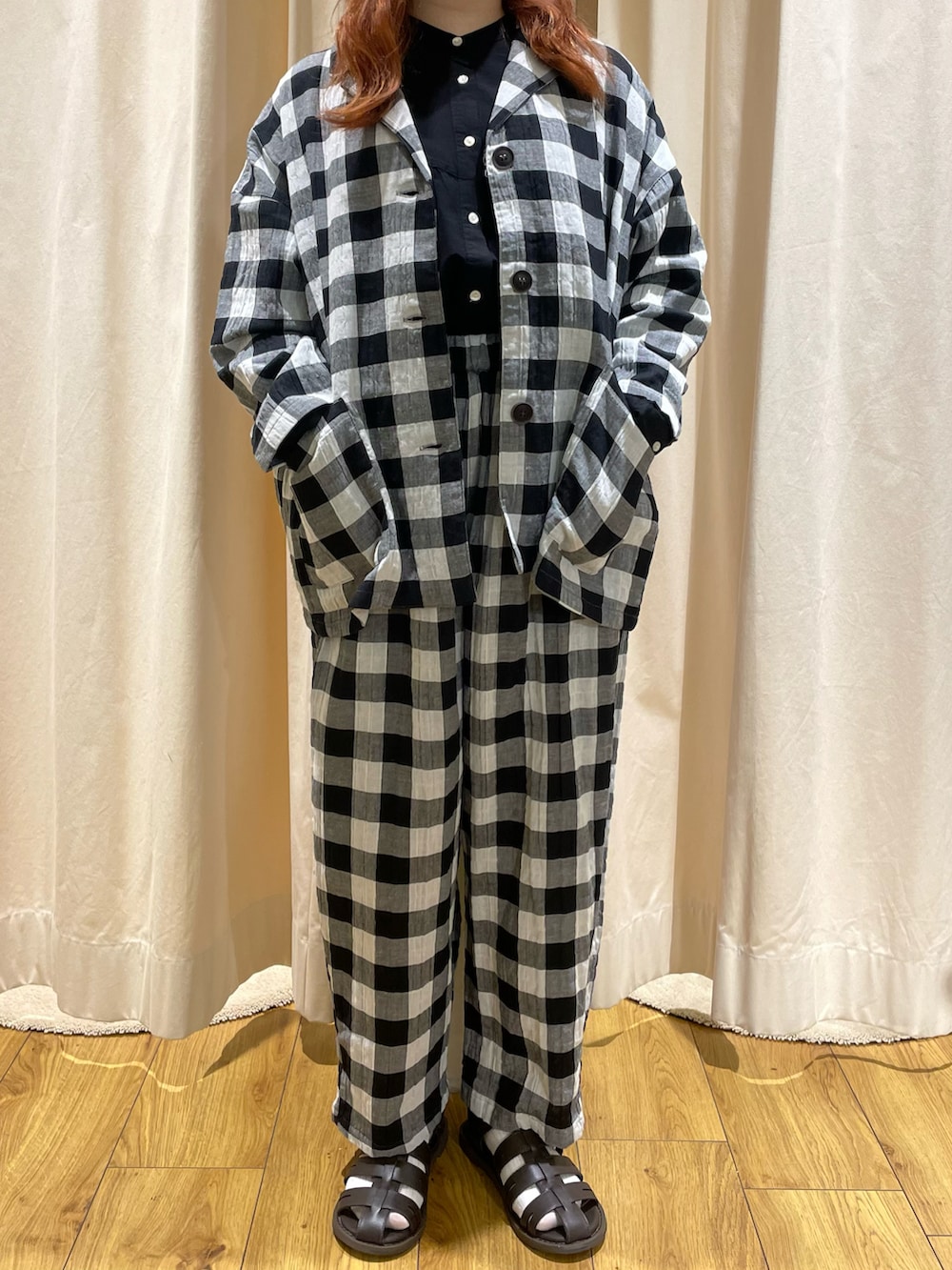 ブラウン系のサンダル、ホワイト系のその他アウター、ブラック系のシャツ/ブラウスを着用したレディースの夏コーディネートの2枚目の写真