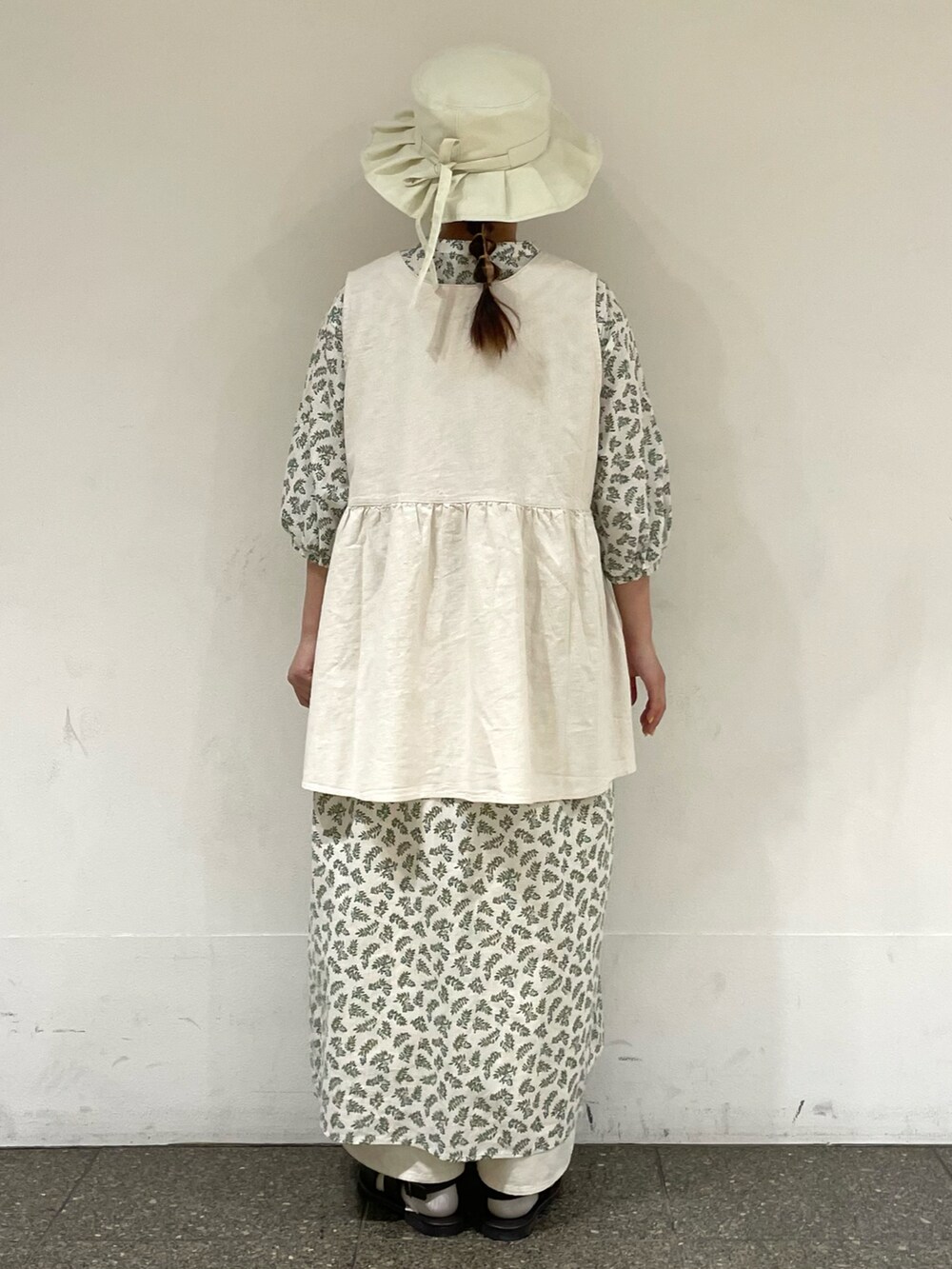 ブラウン系のサンダル、ホワイト系のワンピース、ホワイト系のベストを着用したレディースの秋コーディネートの4枚目の写真