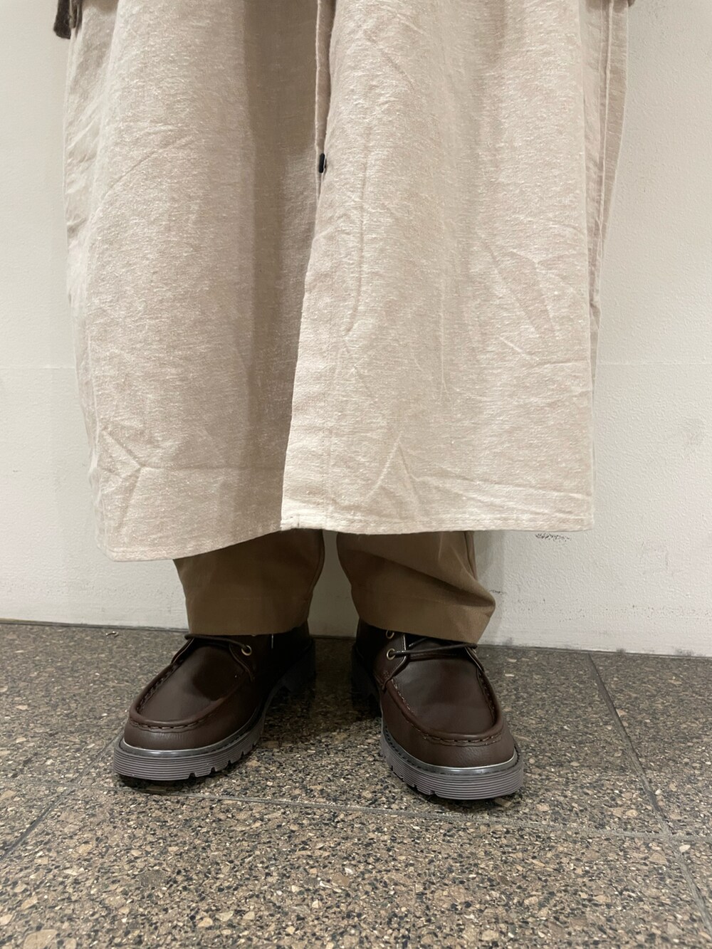 ベージュ系のワンピース、グリーン系のブルゾン、ブラウン系のベストを着用したレディースの冬コーディネートの5枚目の写真