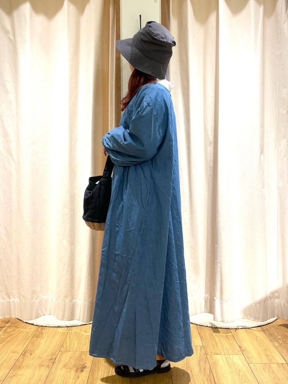 ブラック系のかごバッグ、ホワイト系のシャツ/ブラウス、ブルー系のワンピースを着用したレディースの春コーディネートの3枚目の写真